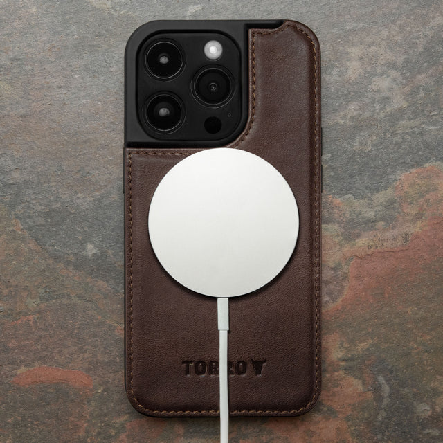 MagSafe charger attached to the Dark Brown Leather Bumper Case for iPhone 15 Pro