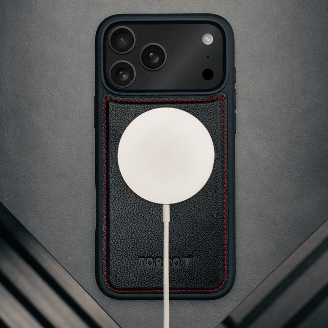 MagSafe charger attached to the Black with Red Detail Leather Detachable Case for iPhone 17 Pro Max