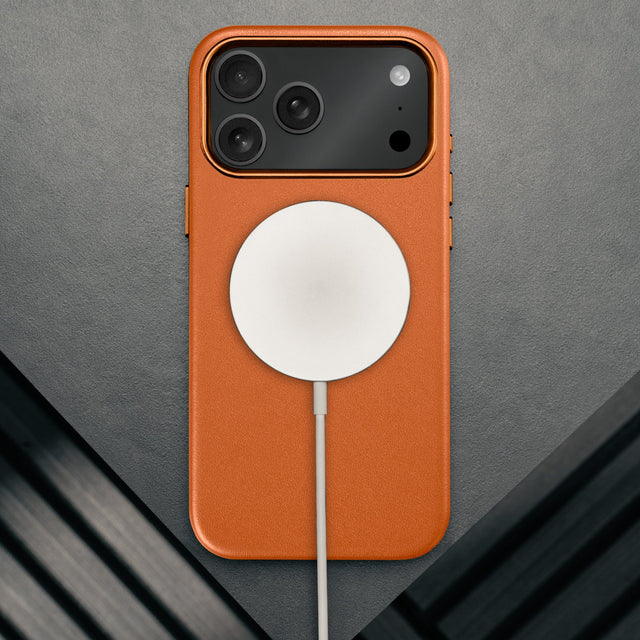 MagSafe charger attached to the Slimline Orange Leather Bumper Case for iPhone 17 Pro Max