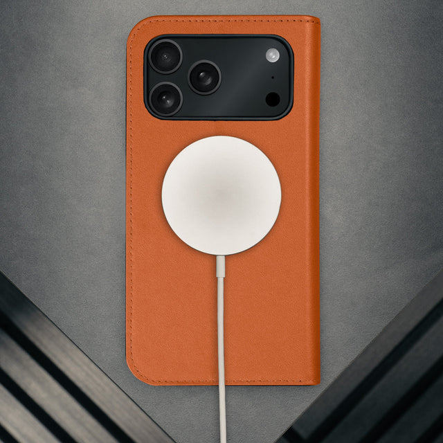 MagSafe charger attached to the Orange Leather Case for iPhone 17 Pro Max